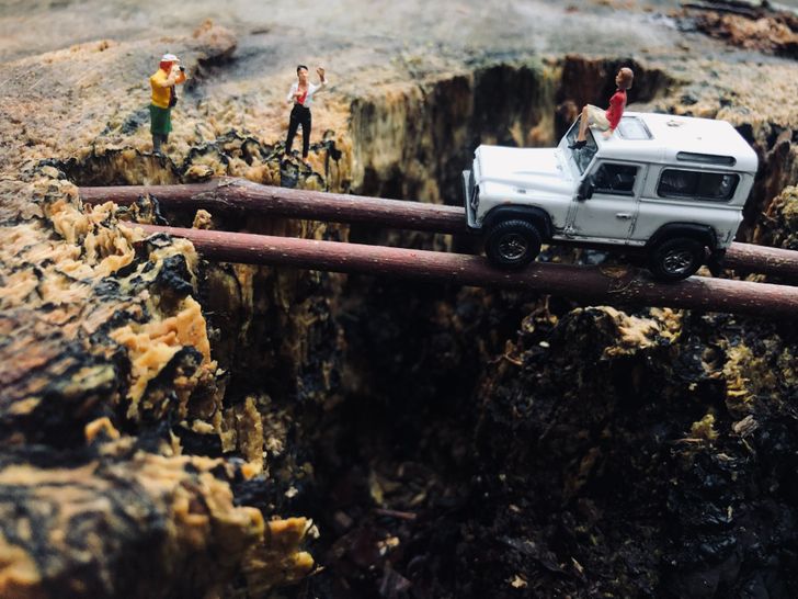 A group crossing a gap using a bridge they built themselves.